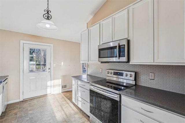 kitchen with stainless steel appliances, tasteful backsplash, dark countertops, visible vents, and pendant lighting