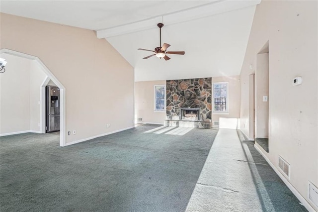 unfurnished living room with visible vents, carpet, beamed ceiling, a ceiling fan, and a stone fireplace