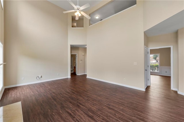 unfurnished living room featuring dark wood-style floors, ceiling fan, and baseboards