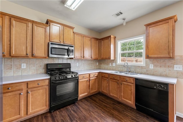 kitchen with dark wood-style flooring, a sink, visible vents, backsplash, and black appliances