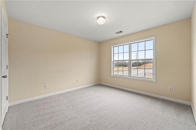 empty room featuring carpet floors, baseboards, and visible vents