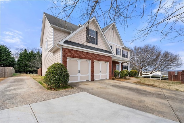 view of property exterior with driveway, a garage, fence, and brick siding