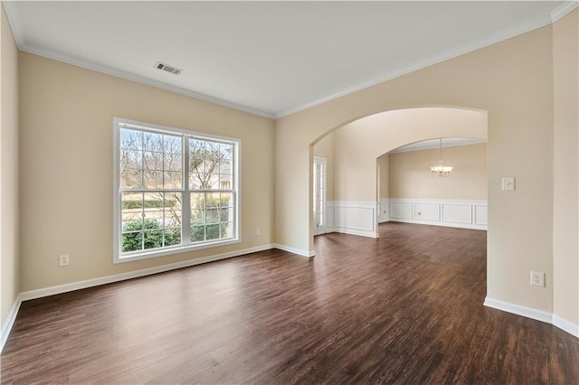 empty room with ornamental molding, arched walkways, visible vents, and dark wood finished floors