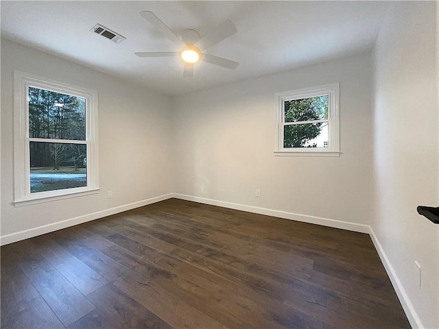 spare room featuring dark wood-type flooring and ceiling fan