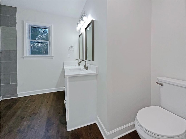 bathroom with toilet, wood-type flooring, and vanity