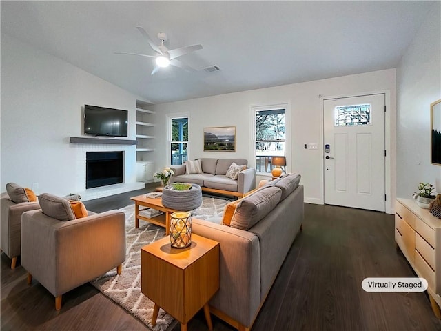 living room with dark wood-type flooring, vaulted ceiling, a fireplace, and ceiling fan