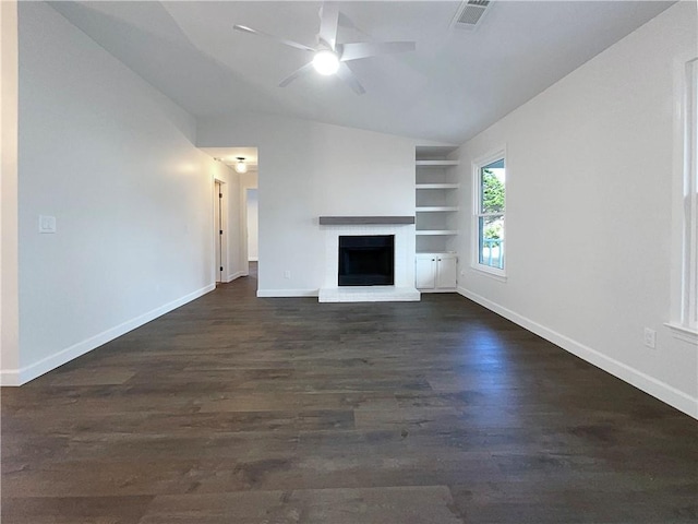 unfurnished living room featuring ceiling fan, vaulted ceiling, a fireplace, built in shelves, and dark hardwood / wood-style flooring