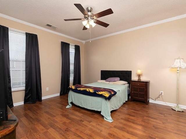 bedroom with ceiling fan, dark hardwood / wood-style flooring, a textured ceiling, and crown molding