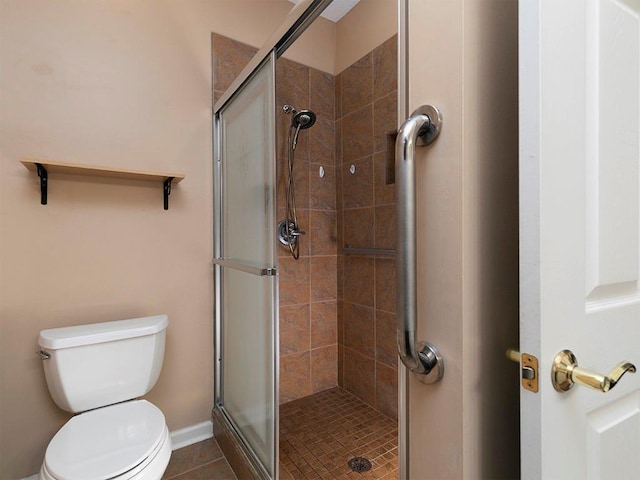 bathroom with tile patterned floors, toilet, and walk in shower