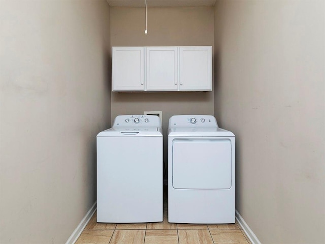 washroom featuring cabinets, washer and dryer, and light tile patterned flooring