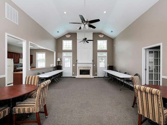 carpeted living room featuring ceiling fan, a fireplace, and high vaulted ceiling