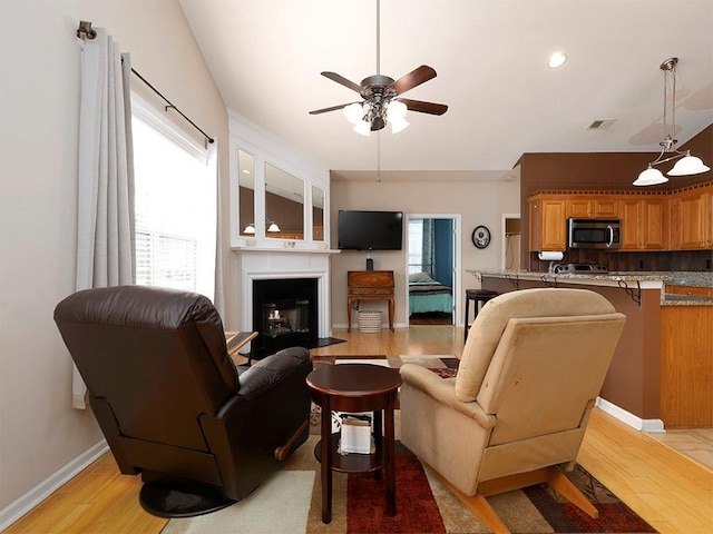 living room featuring light wood-type flooring, a wealth of natural light, and ceiling fan