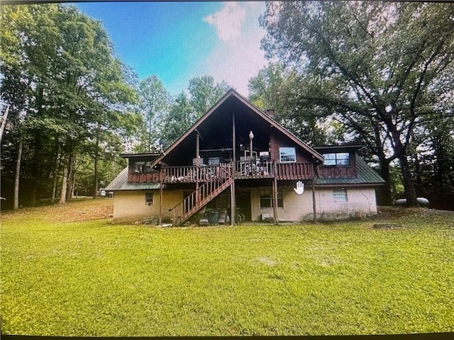 back of property featuring a wooden deck and a lawn