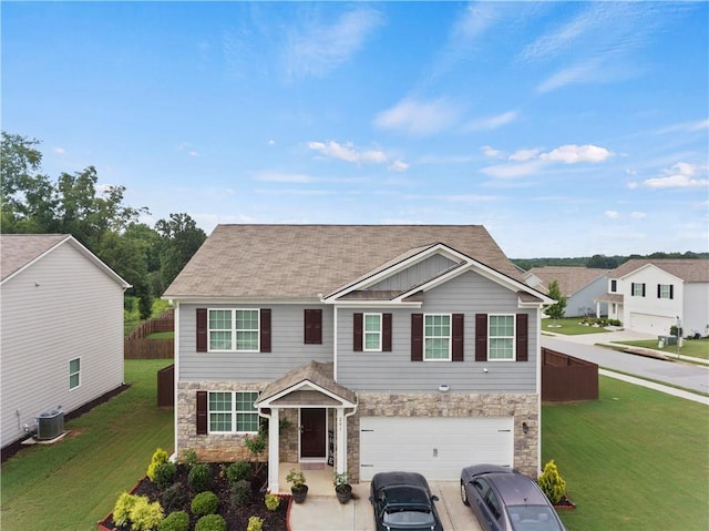 view of front of house with a front yard, central AC, and a garage