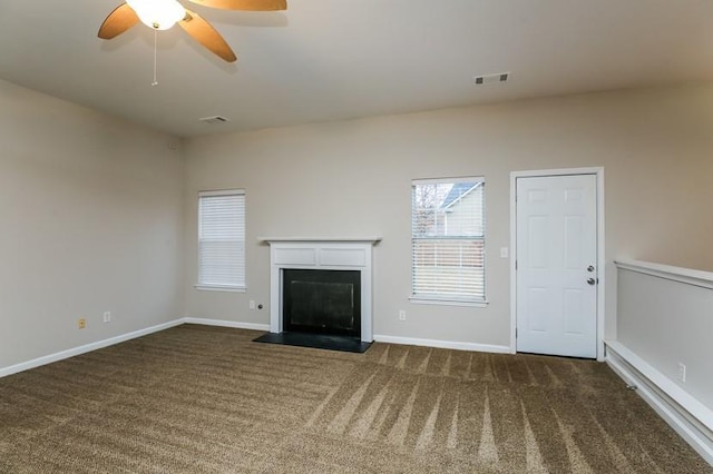 unfurnished living room featuring dark carpet and ceiling fan