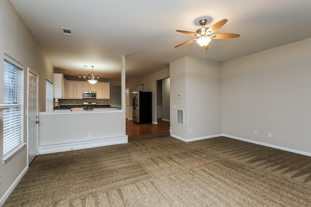 unfurnished living room featuring ceiling fan and dark carpet