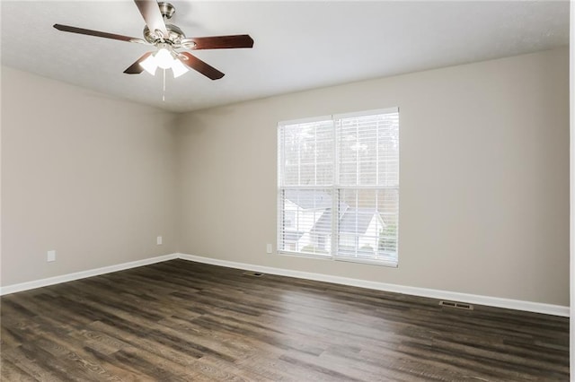 spare room featuring dark wood-type flooring, baseboards, visible vents, and ceiling fan