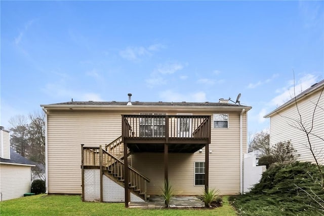 rear view of property with stairway, a wooden deck, and a yard
