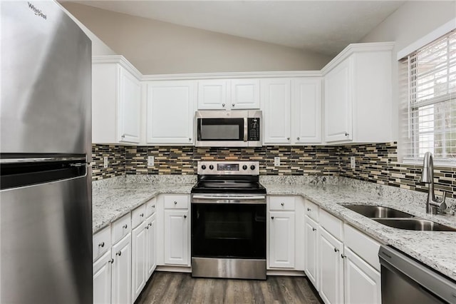 kitchen featuring a sink, lofted ceiling, dark wood-style flooring, white cabinetry, and appliances with stainless steel finishes
