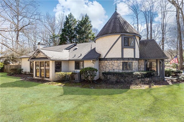 rear view of property featuring stone siding, a lawn, roof with shingles, stucco siding, and a chimney