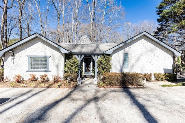 view of front of house with roof with shingles and stucco siding