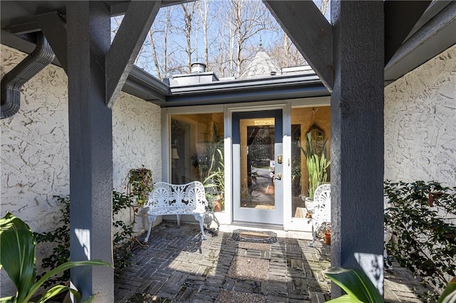 doorway to property featuring a patio, french doors, and stucco siding