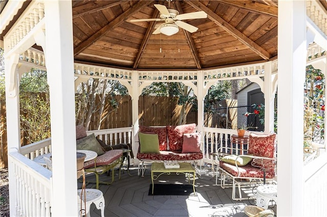 exterior space featuring vaulted ceiling with beams, wood ceiling, and a ceiling fan