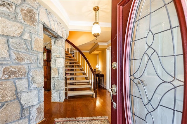 foyer with ornamental molding, stairway, wood finished floors, and decorative columns