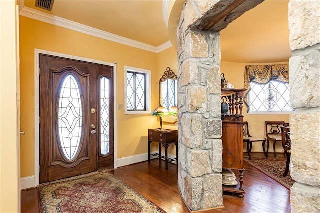 entrance foyer with ornamental molding, a wealth of natural light, visible vents, and hardwood / wood-style floors