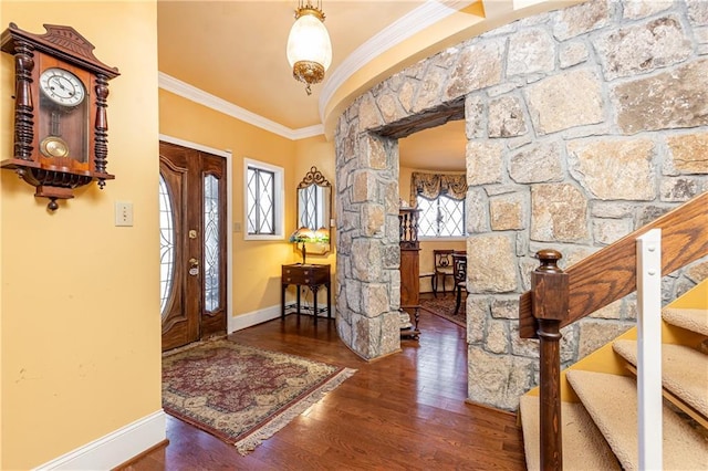 foyer featuring baseboards, wood finished floors, and crown molding