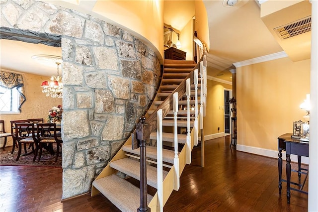 stairway featuring baseboards, hardwood / wood-style flooring, visible vents, and crown molding