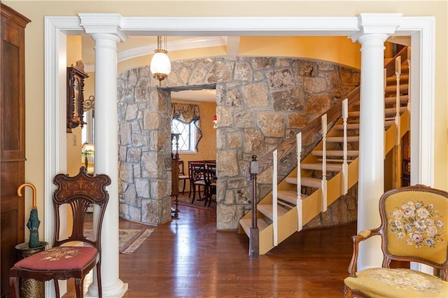 interior space with ornamental molding, wood finished floors, and decorative columns