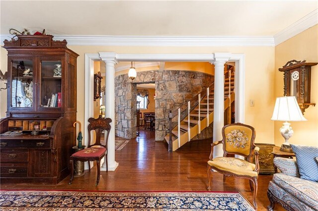 sitting room featuring ornamental molding, stairs, decorative columns, and wood finished floors