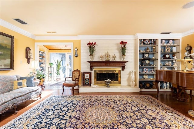 living room featuring a brick fireplace, visible vents, and ornamental molding