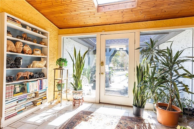 entryway featuring vaulted ceiling with skylight, wooden ceiling, and tile patterned floors