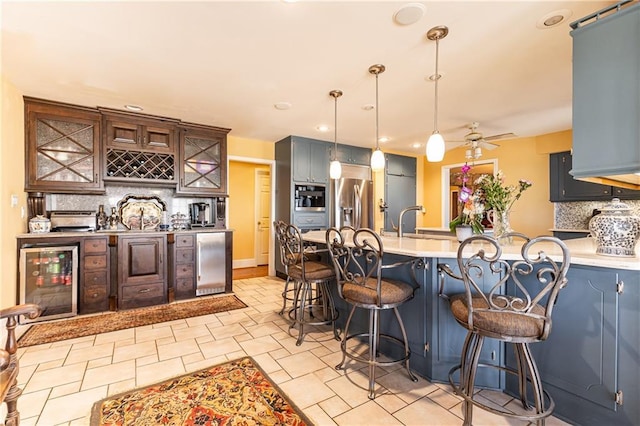 kitchen featuring refrigerator, beverage cooler, a peninsula, decorative backsplash, and stainless steel fridge