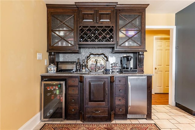 bar with a bar, beverage cooler, tasteful backsplash, and stainless steel fridge