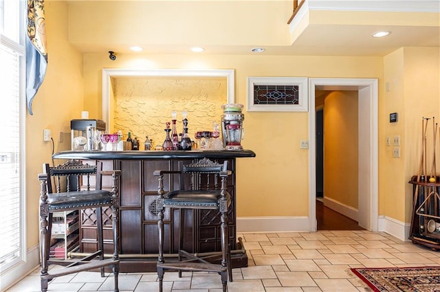 bar featuring a dry bar, baseboards, and recessed lighting