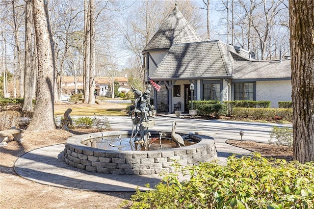 back of house featuring a shingled roof and stucco siding