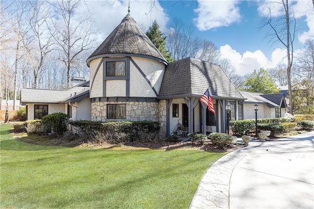 view of front facade with stone siding, roof with shingles, a front lawn, and stucco siding