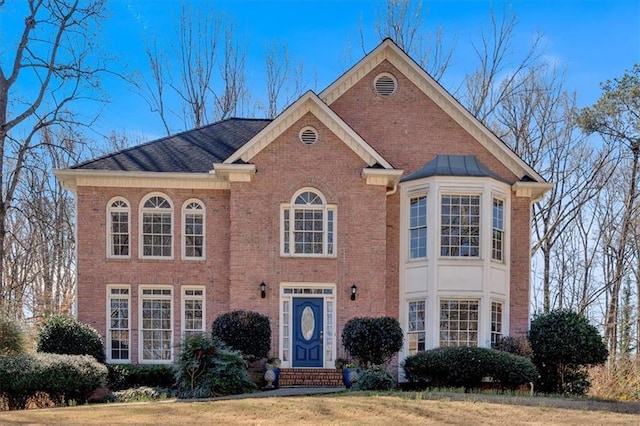 view of front of house featuring a front yard and brick siding