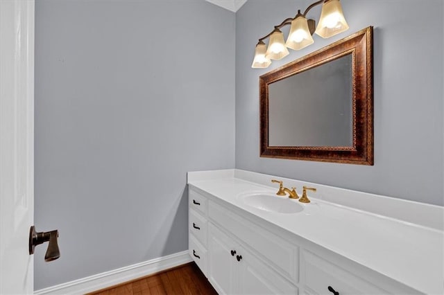 bathroom featuring vanity, baseboards, and wood finished floors