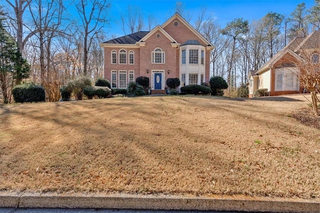 colonial house with brick siding and a front lawn