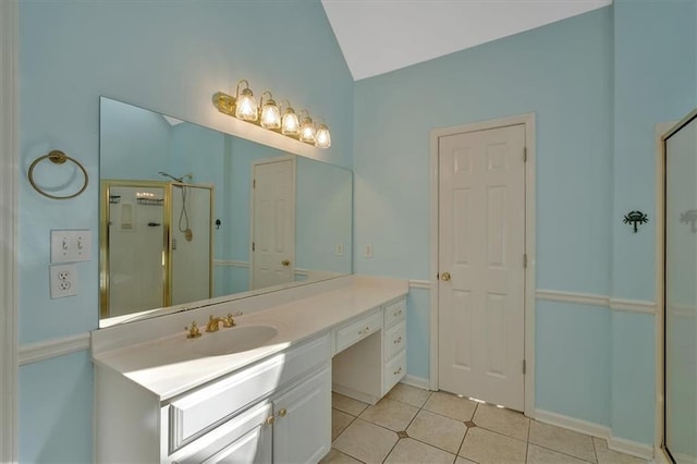 bathroom with baseboards, vaulted ceiling, a stall shower, tile patterned floors, and vanity