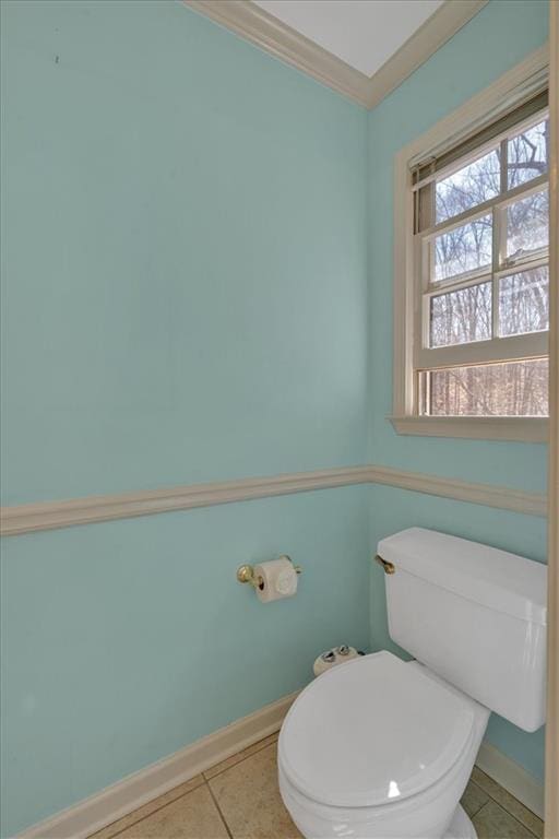 bathroom featuring tile patterned floors, baseboards, toilet, and ornamental molding