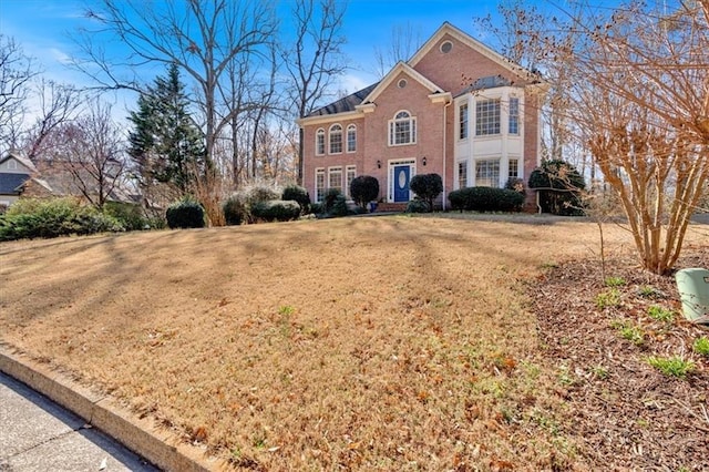 view of front of home with a front lawn and brick siding