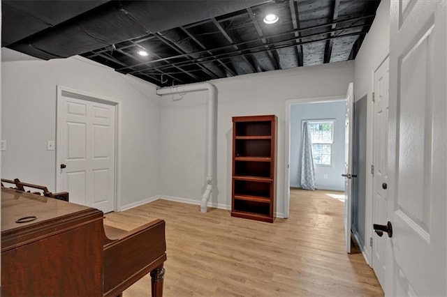 interior space featuring baseboards and light wood finished floors