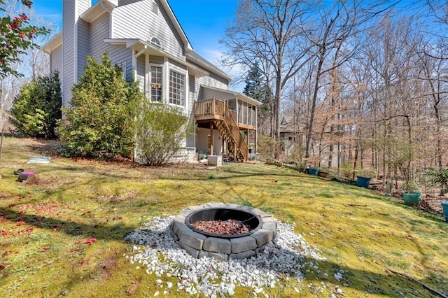 exterior space with stairway, a fire pit, and a wooden deck