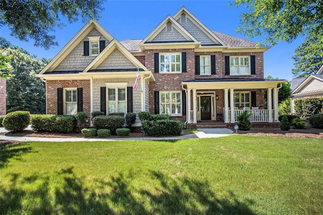 craftsman-style house featuring covered porch and a front yard