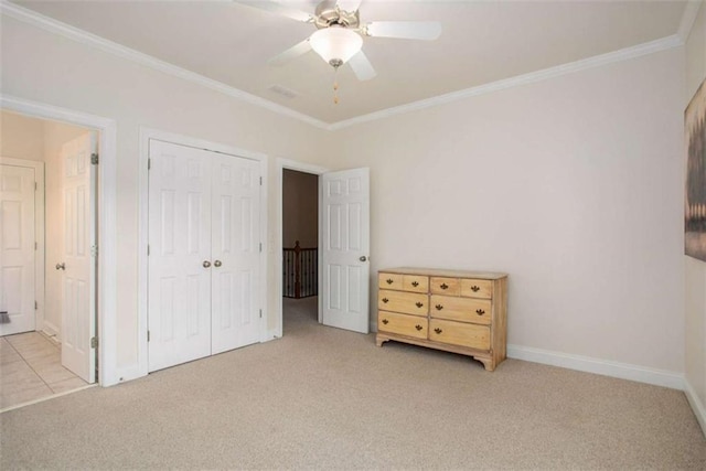 unfurnished bedroom featuring a closet, ceiling fan, crown molding, and light colored carpet